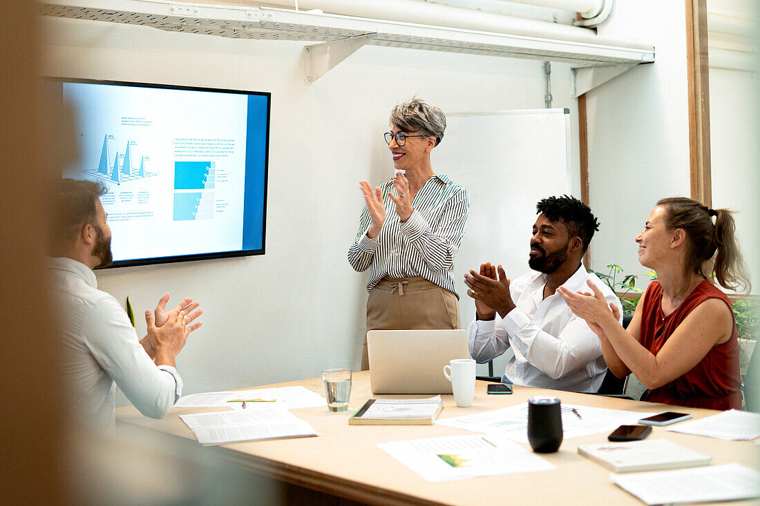 Coworkers celebrating project presentation made by businesswomen