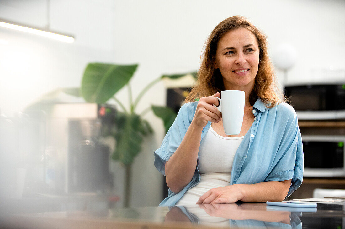 Unternehmerin bei einer Kaffeepause im Büro