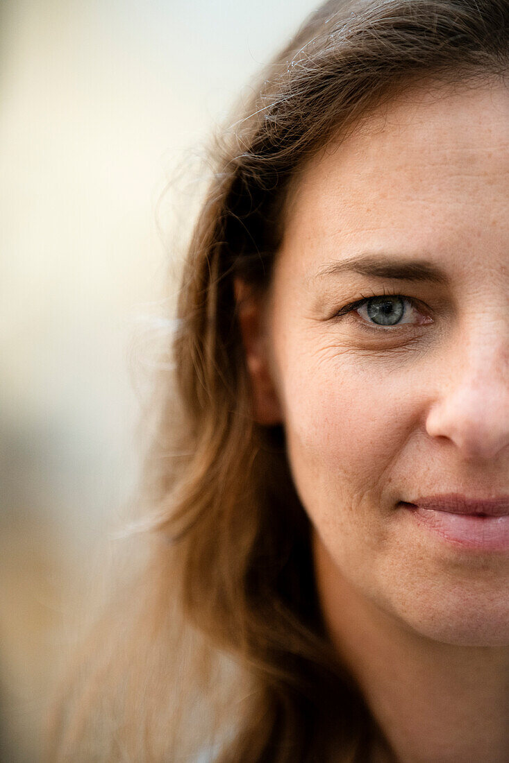 Portrait of half face of adult woman looking at camera