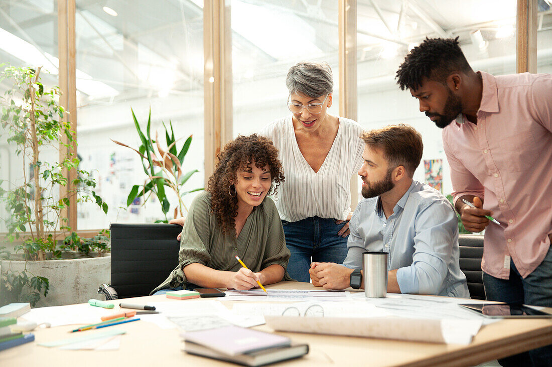 Young adult businesswoman presenting work to coworkers