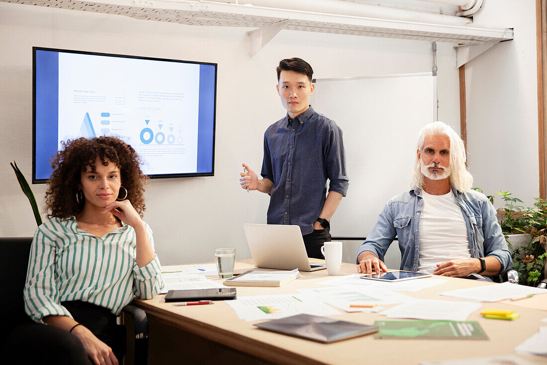 Businesswoman and businessmen looking at the camera during meeting