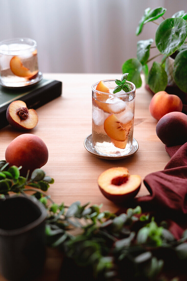Sommerlicher Pfirsichdrink mit klaren Gläsern und Eis