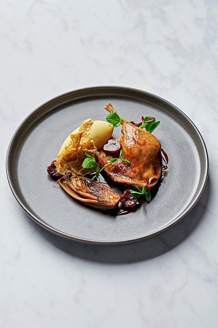 Confit duck leg, creamy puree, caramelised chicory, sour cherry jus, filo waffle dusted with pistachios