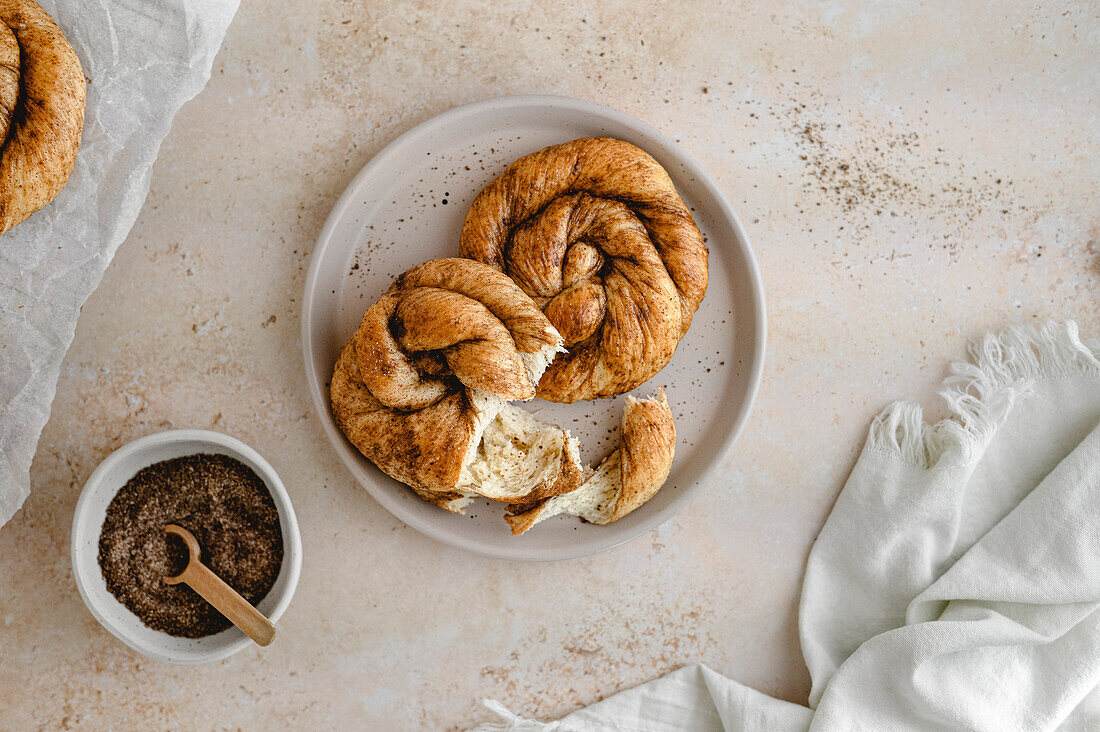 Homemade Dutch cinnamon buns on a plate with brown sugar