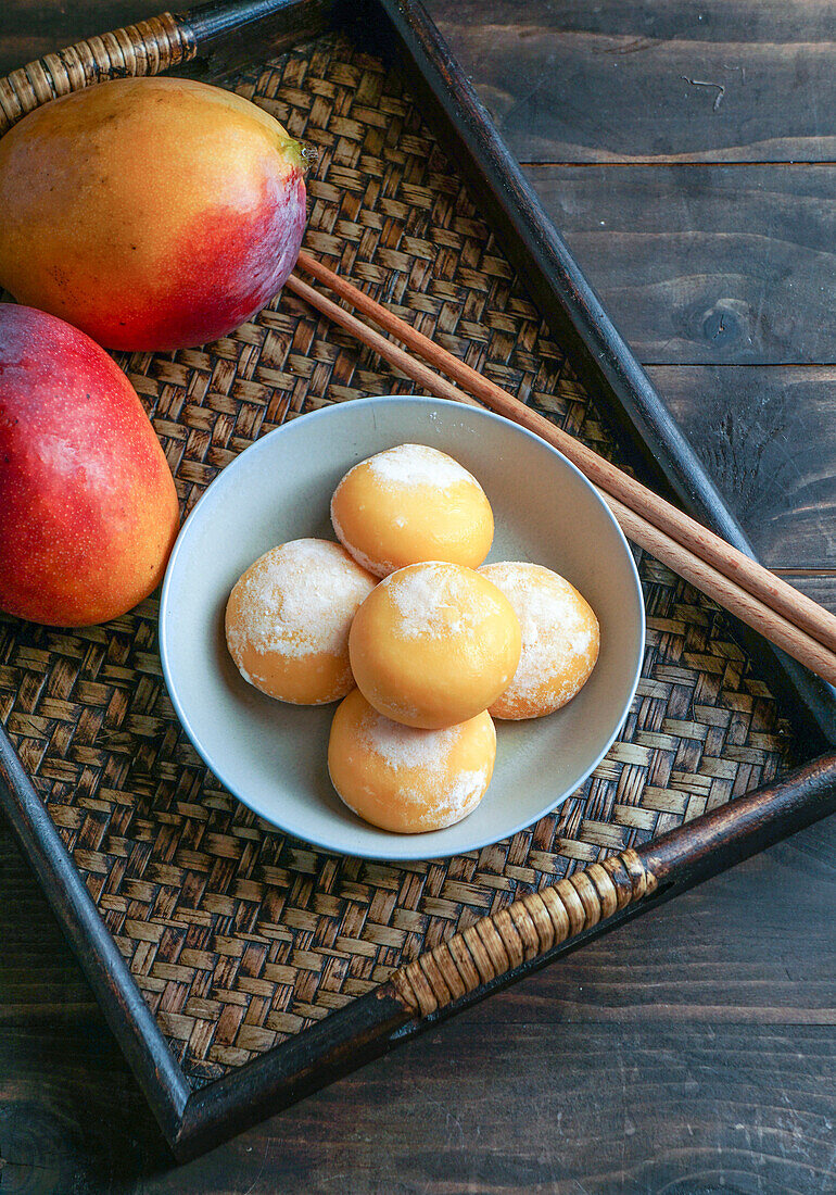 Japanese mango mochi cupcakes with ice cream on a classic Asian wooden tray