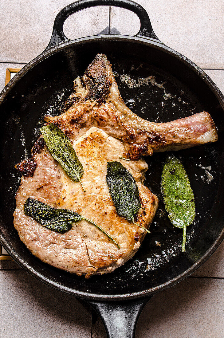 Pork chops with butter and sage in a pan