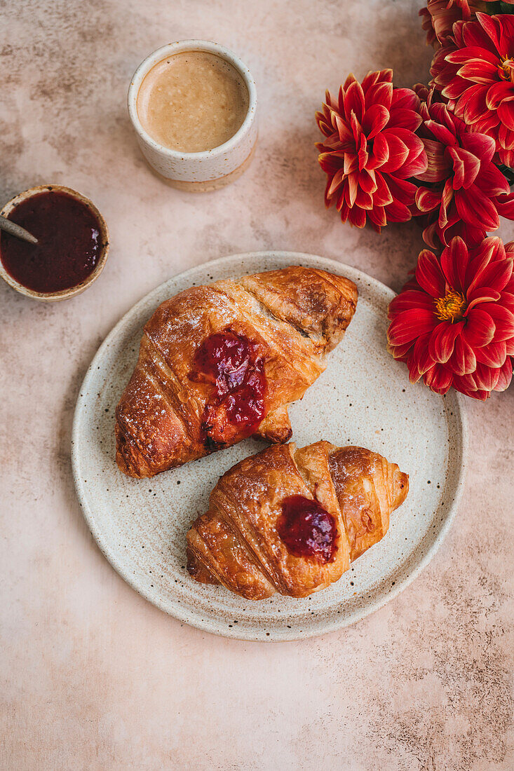 Croissants with strawberry jam on a ceramic plate