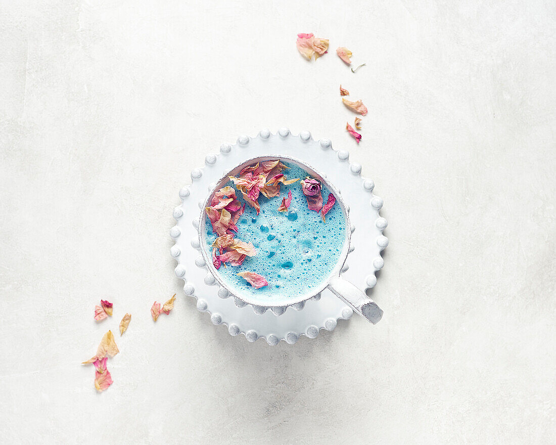 Butterfly pea blossom tea latte with dried rose petals