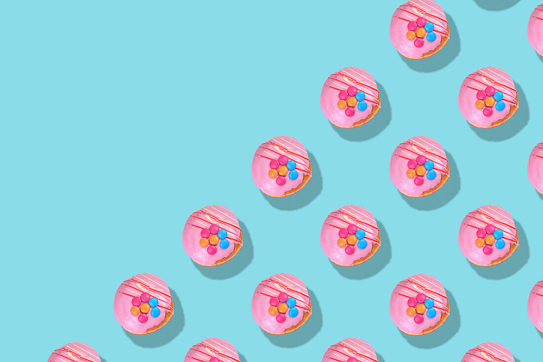 Modernes Retro-Farbmuster von rosa Donuts vor einem aquablauen Hintergrund mit negativem Kopierraum