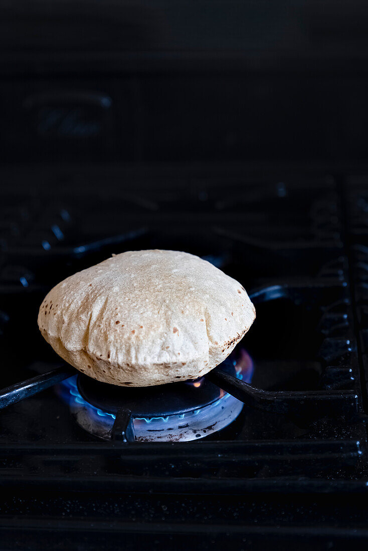 Phulka Roti auf der Flamme gekocht