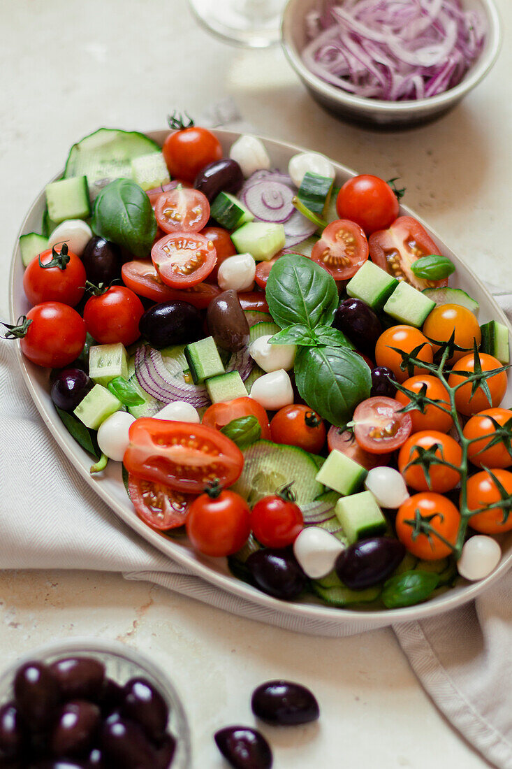 Bowl of Greek salad on a light coloured background