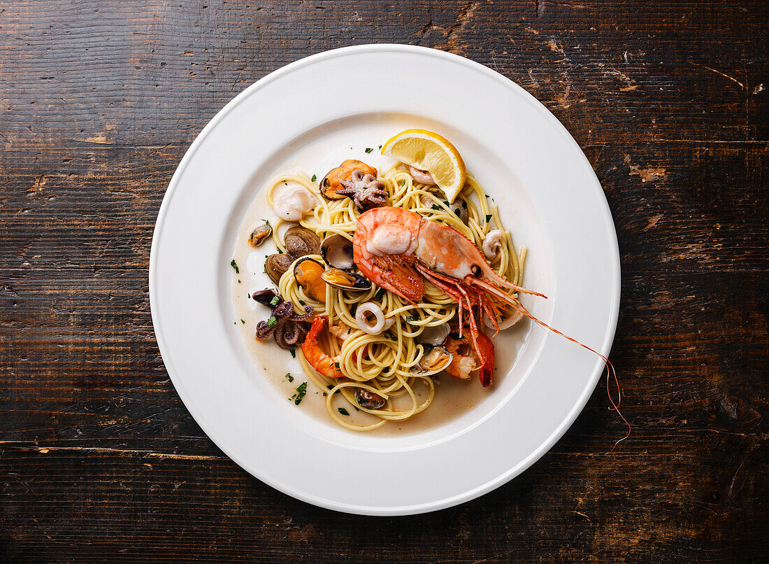 Meeresfrüchte-Pasta Spaghetti mit Venusmuscheln, Garnelen, Meeresfrüchte-Cocktail auf weißem Teller