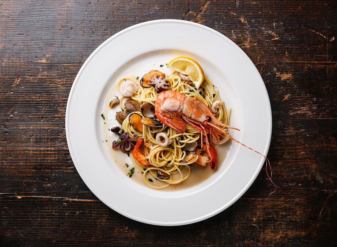 Seafood pasta spaghetti with clams, prawns, seafood cocktail on a white plate