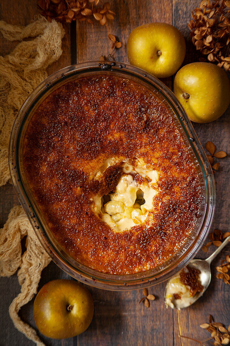 Serving bowl of Malvern pudding apple brulee, the lid of which is cracked and from which a portion has been removed