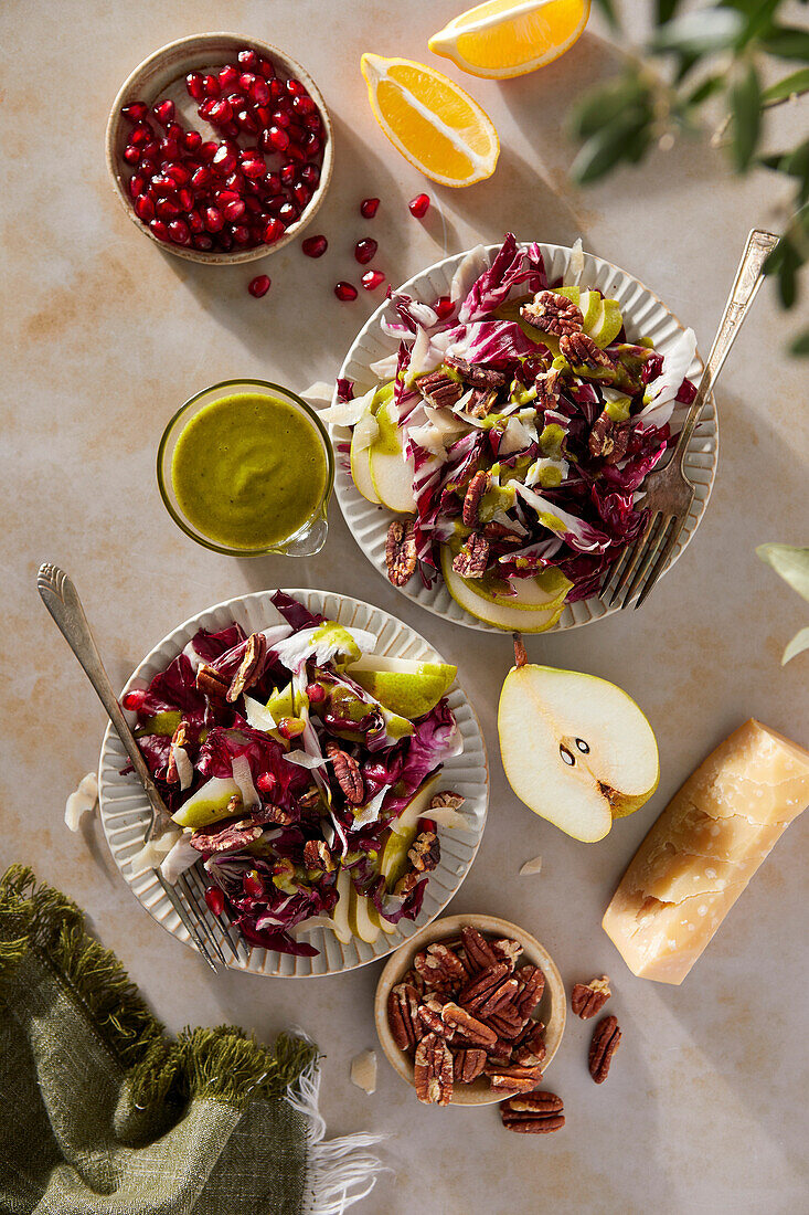 Radicchio Salad with Pears, Pecans, Pomegrate, Pecans and Basil Vinaigrette on a neutral brown background with a green cloth.