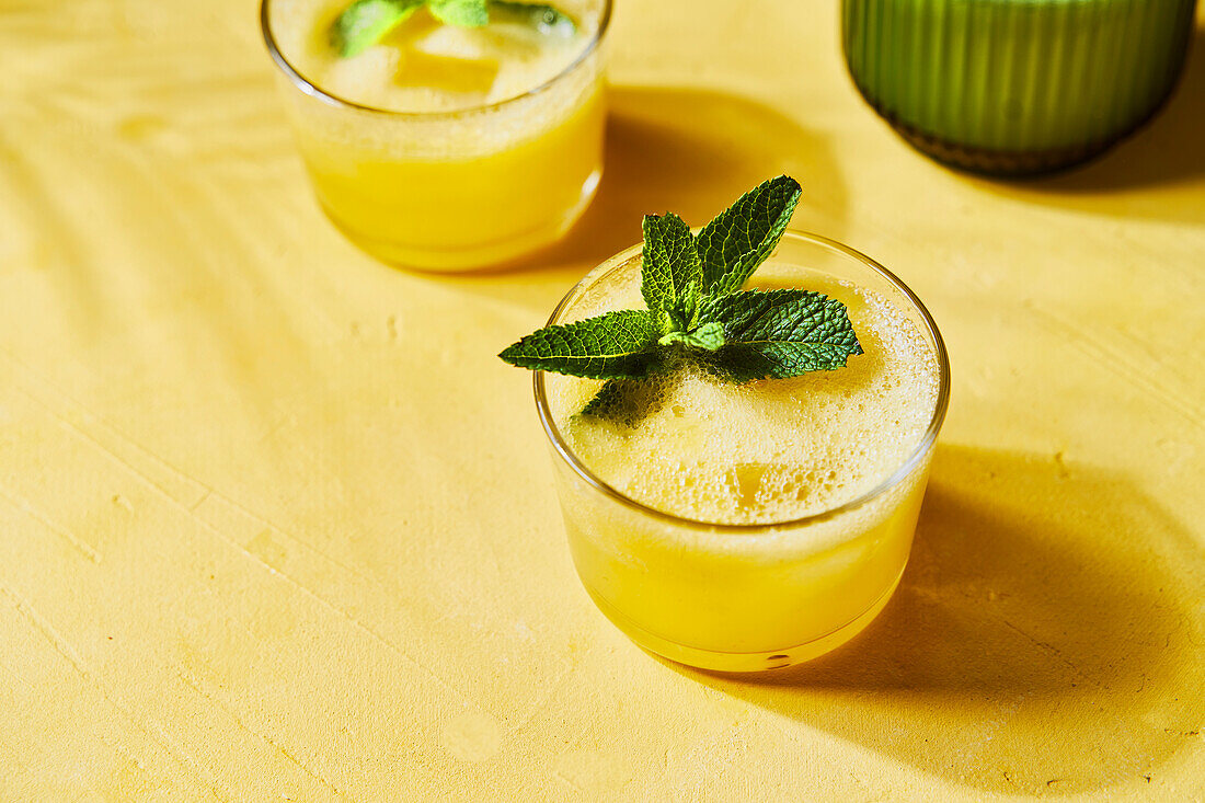 Pineapple mint G&Ts with spout on yellow background with shadow