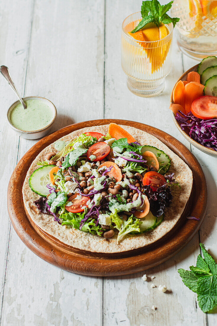 Open wrap with fresh, raw vegetables and a mint yoghurt dip