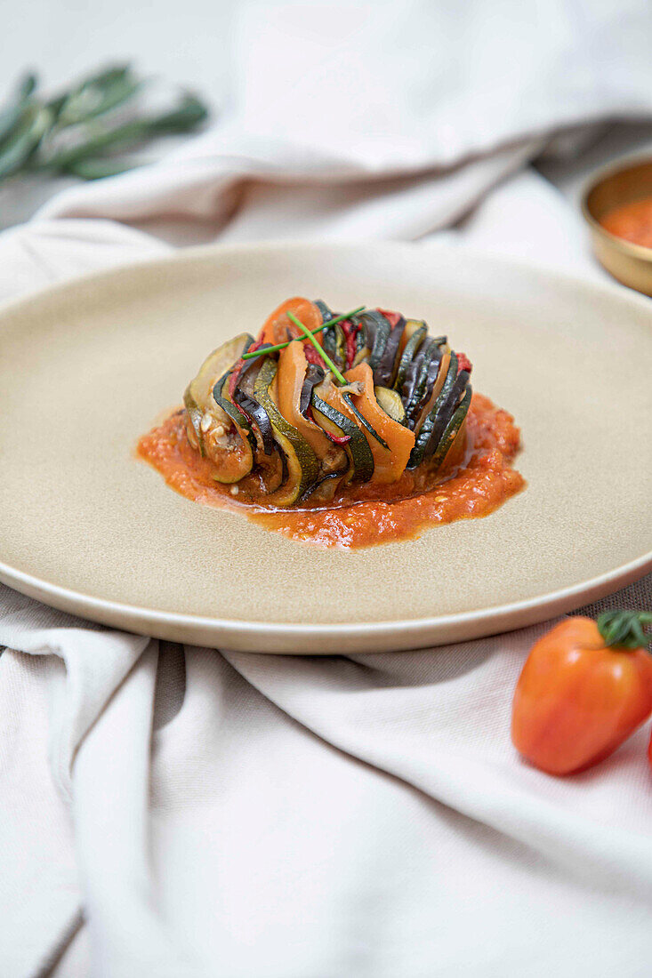A modern take on Ratatouille, or mixed stewed vegateables, served on a ceramic plate