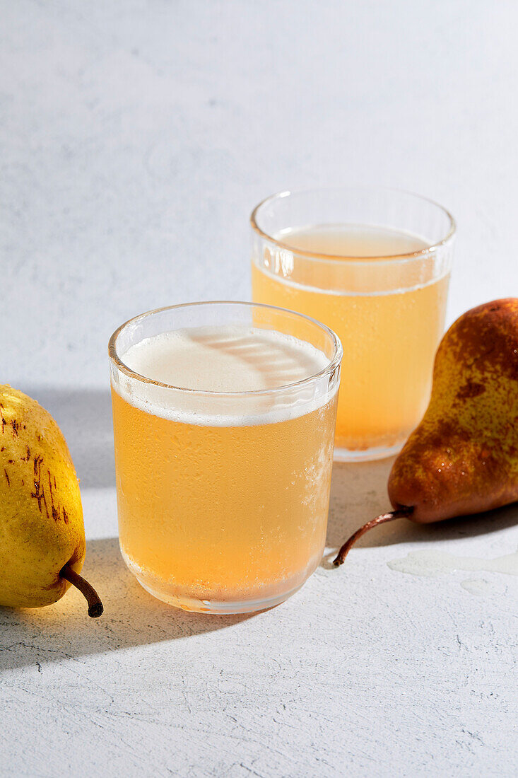 Birnencidre auf hellem Hintergrund mit hartem Licht