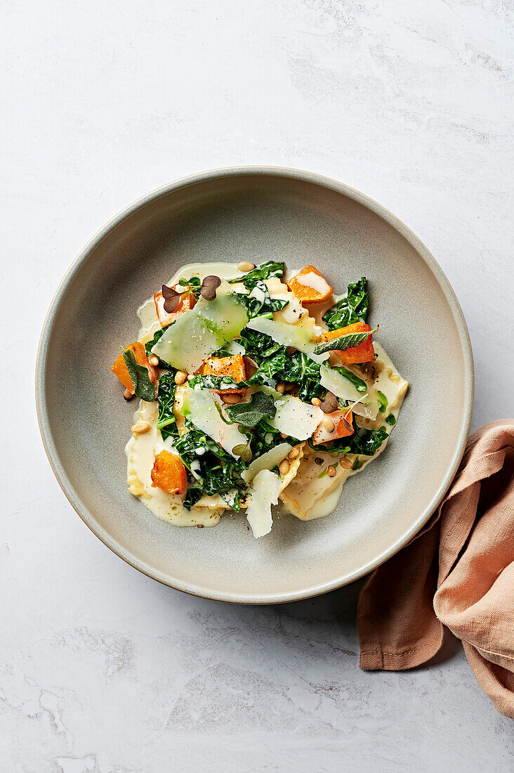 Roasted pumpkin and Parmesan ravioli, cavolo nero, roasted butternut squash, sage cream sauce, toasted pine nuts and shaved Parmesan cheese