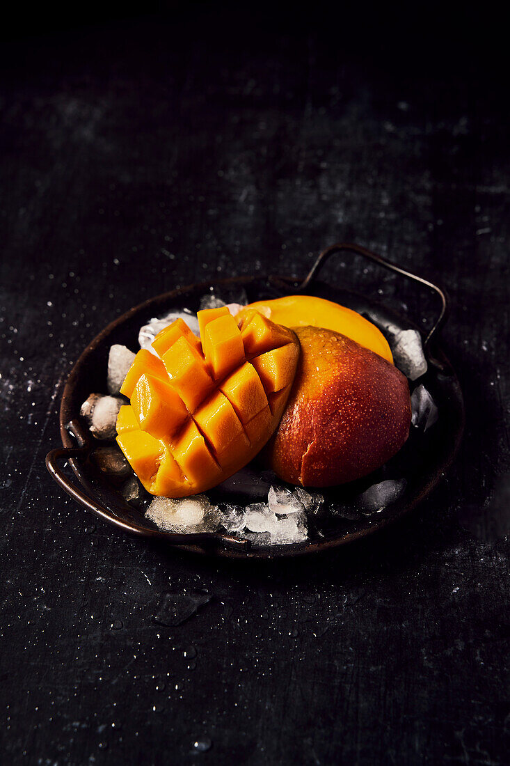 Fresh mango on a black tray and black background