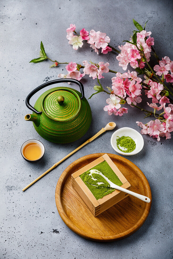 Matcha Tiramisu Dessert und Grüner Tee auf Betonhintergrund