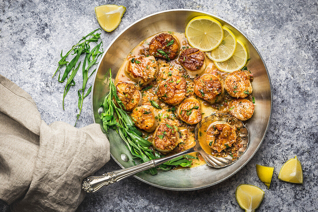 Seared Scallops with Brown Butter sauce in skillet with tarragon and lemon, with linen napkin