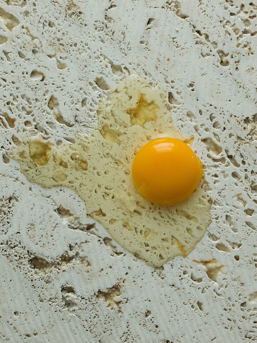 Broken raw egg on a stone