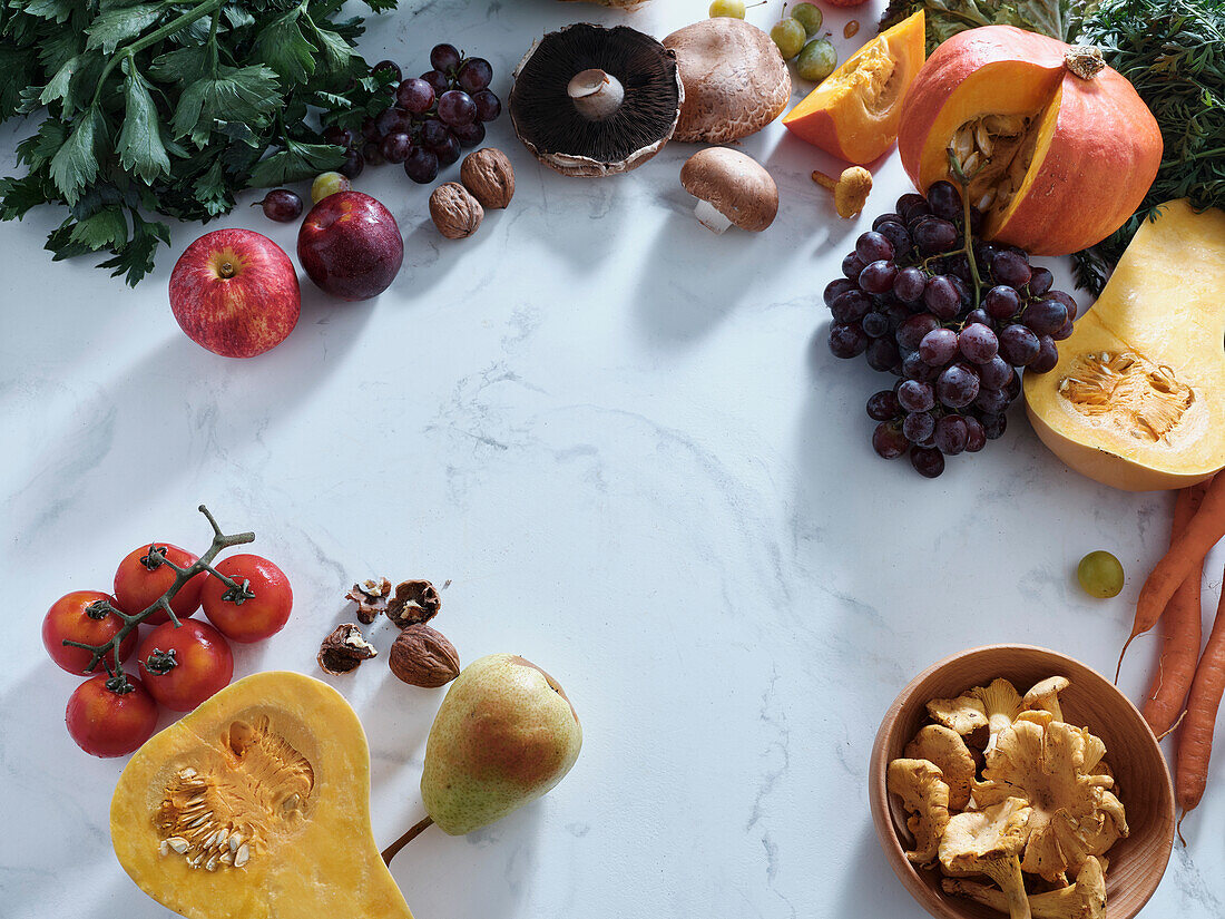 Healthy seasonal vegetarian food. Flat plate with autumn vegetables, fruit and mushrooms from the local market with text field. Vegan ingredients