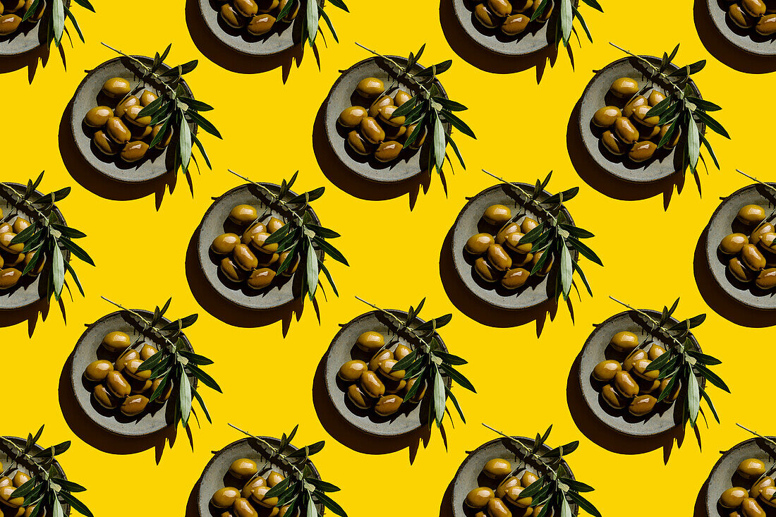 Green olives on plate on yellow background Seamless pattern