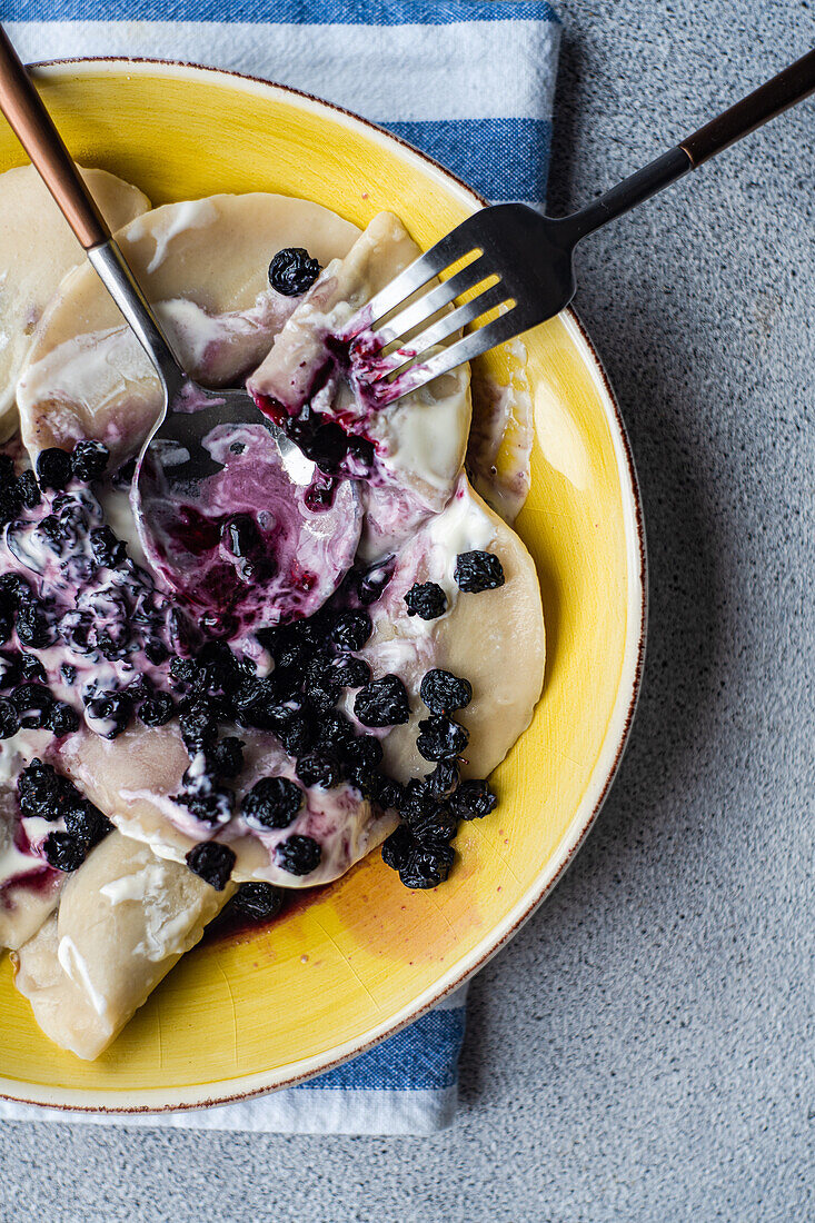 Tasty traditional Ukrainian dumplings with blueberry and sour cream