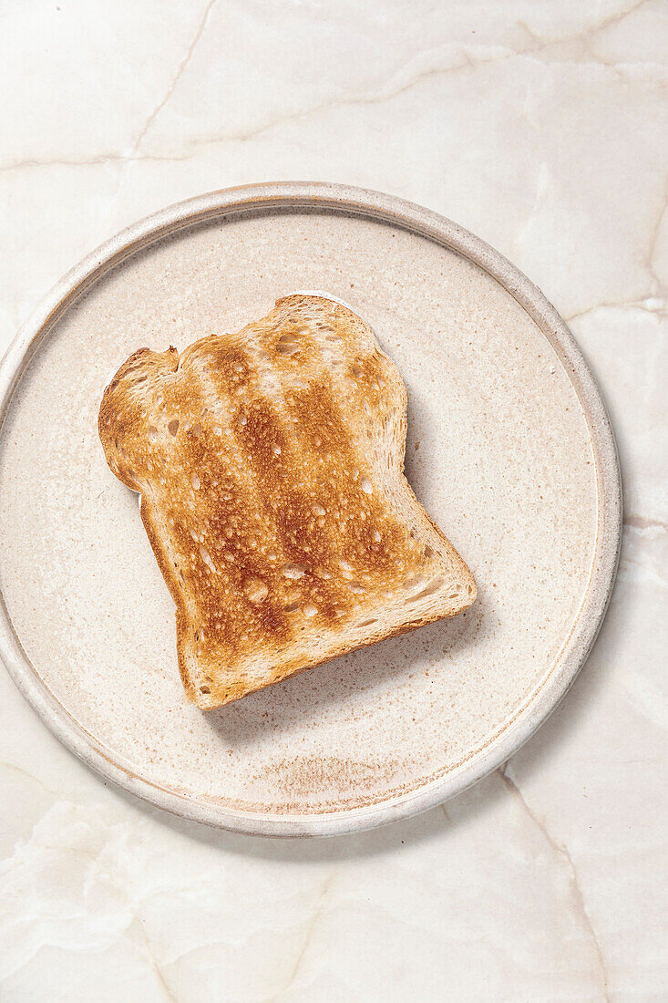 Toast on ceramic plate in front of a marble background