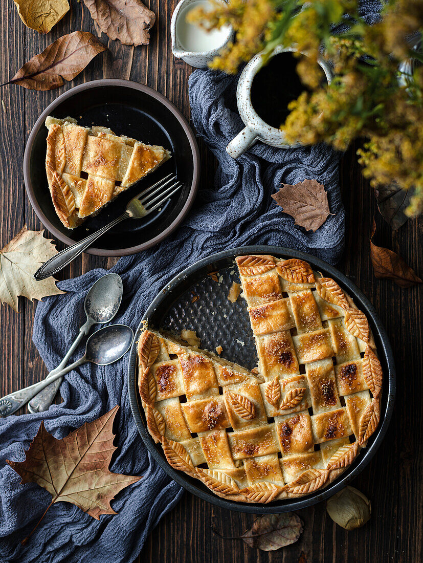 Apple pie in a baking tin on a rustic autumn table