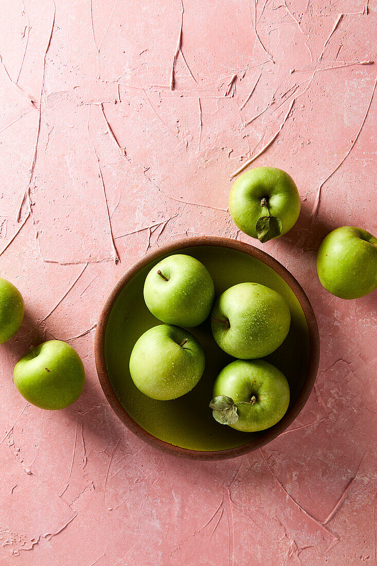 Green apples on a pink background
