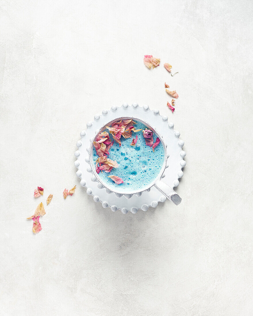 Butterfly pea blossom tea latte with dried rose petals