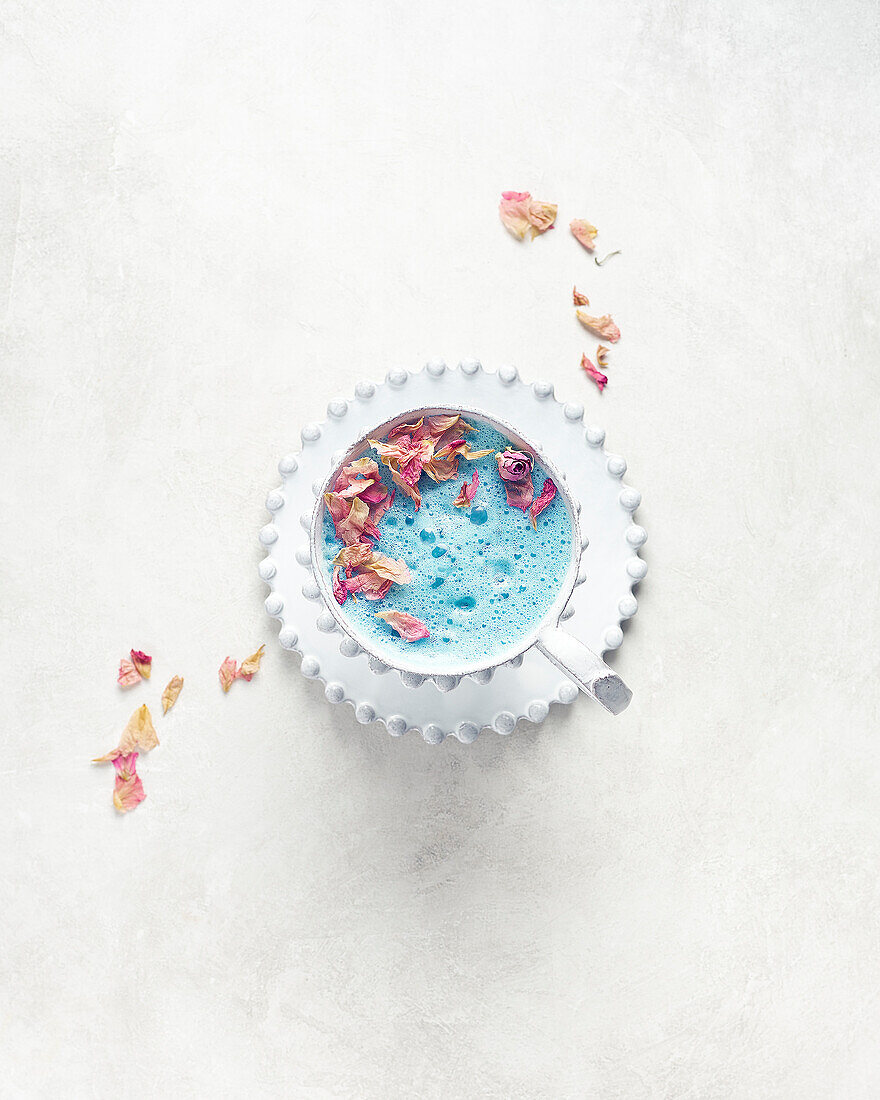 Schmetterlings-Erbsenblüten-Tee-Latte mit getrockneten Rosenblättern