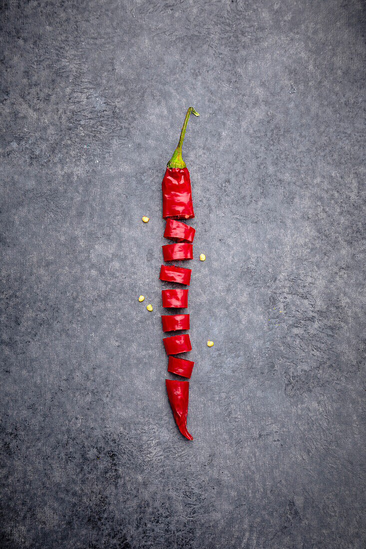 Sliced chilli pepper on a grey background