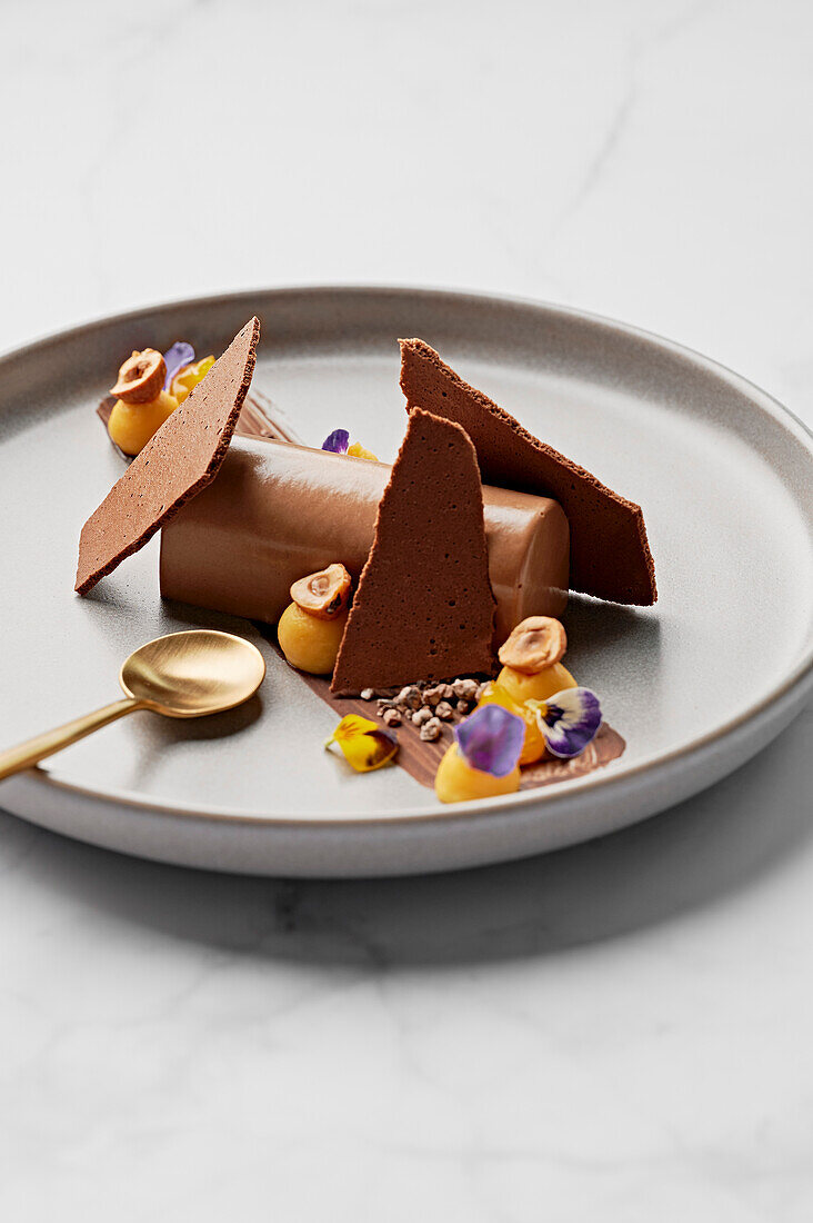 Chocolate mousse, passion fruit curd, candied hazelnuts, cocoa nib praline, passion fruit gel, dried chocolate