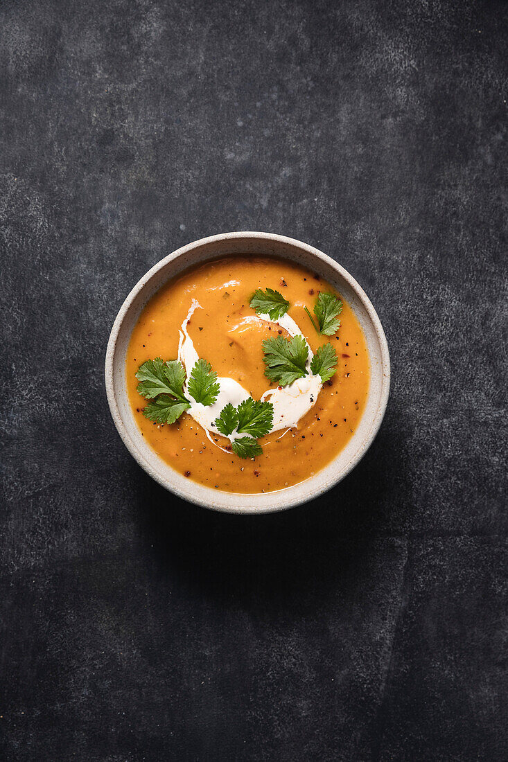 Butternusskürbissuppe auf dunklem Hintergrund