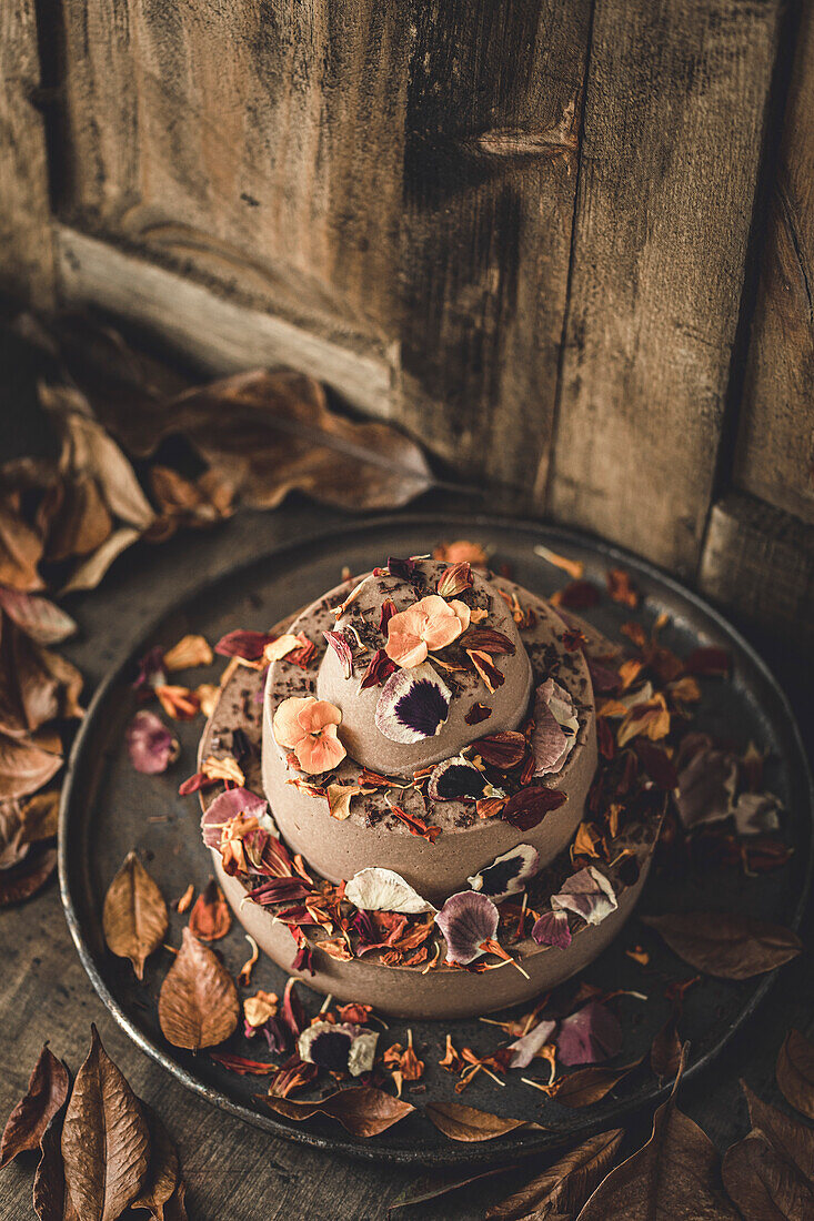 Chocolate cake decorated with edible flowers and leaves