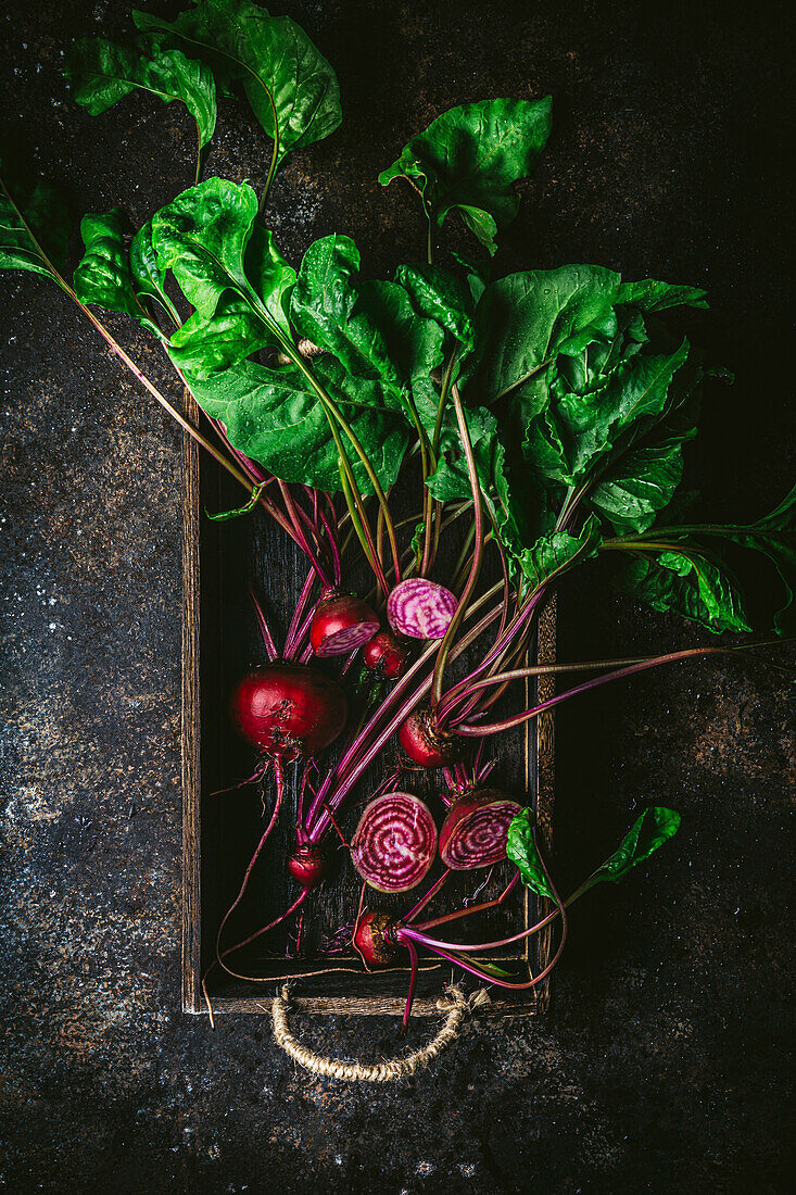 Beetroot, some sliced, with leaves, in wooden box