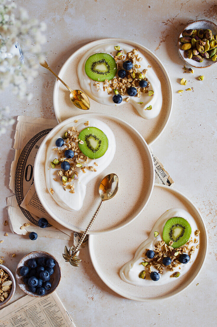 Joghurt mit Kiwi, Blaubeeren, Granola und Pistazien