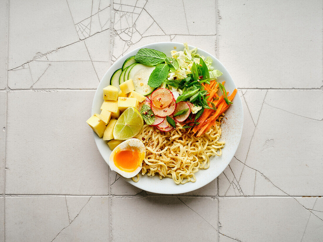 Salat Ramen - vegetarisches Gericht mit Eiernudeln, Mango, Limette und Gemüse. Gesunde panasiatische Küche