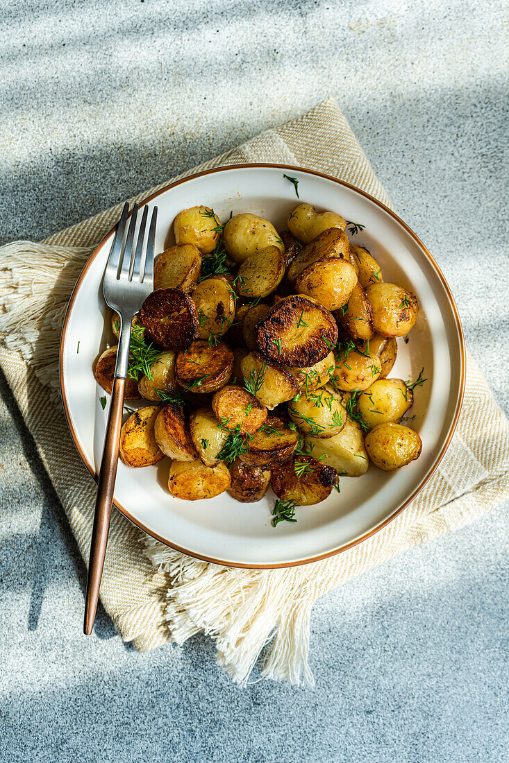 Roasted spring potato with fresh dill herb and raw vegetable salad served in the bowl