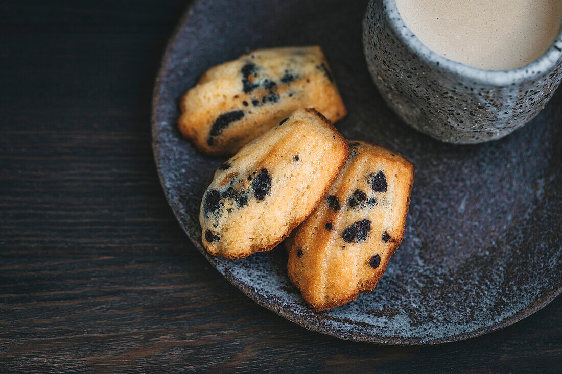French madeleines biscuits on a ceramic plate, served with coffee