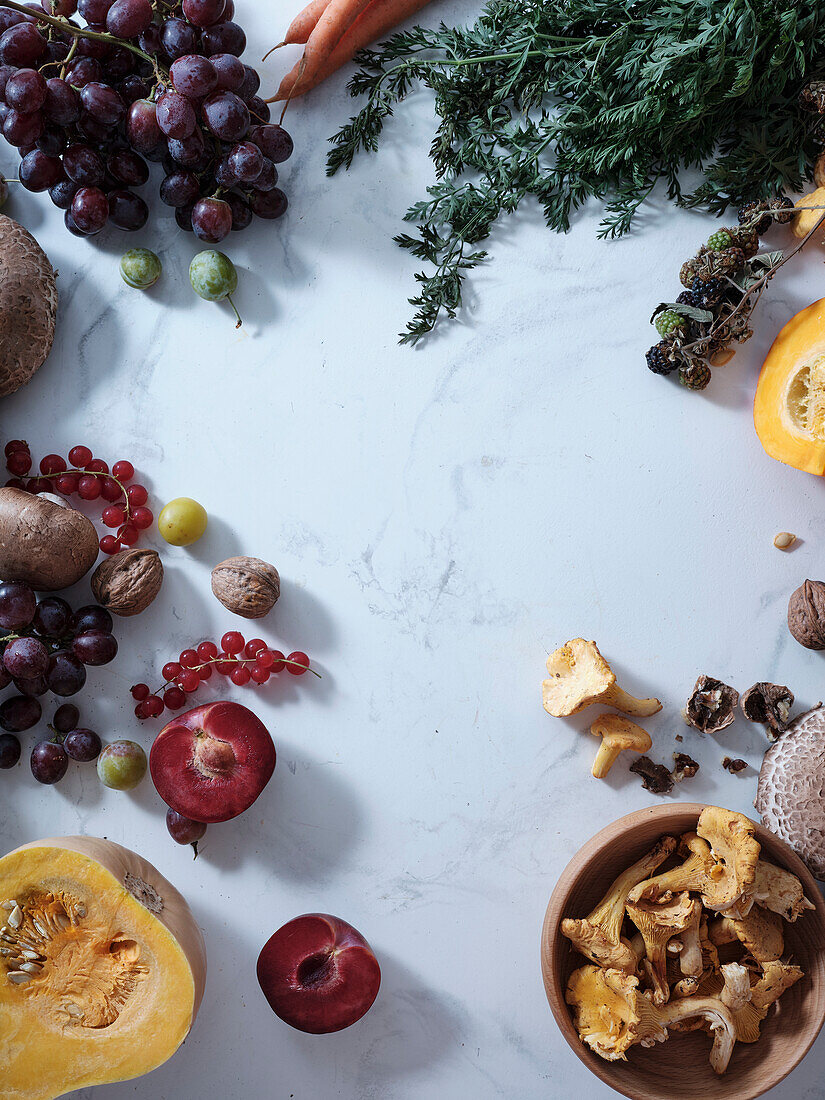 Healthy seasonal vegetarian food. Flat plate with autumn vegetables, fruit and mushrooms from the local market with text field. Vegan ingredients