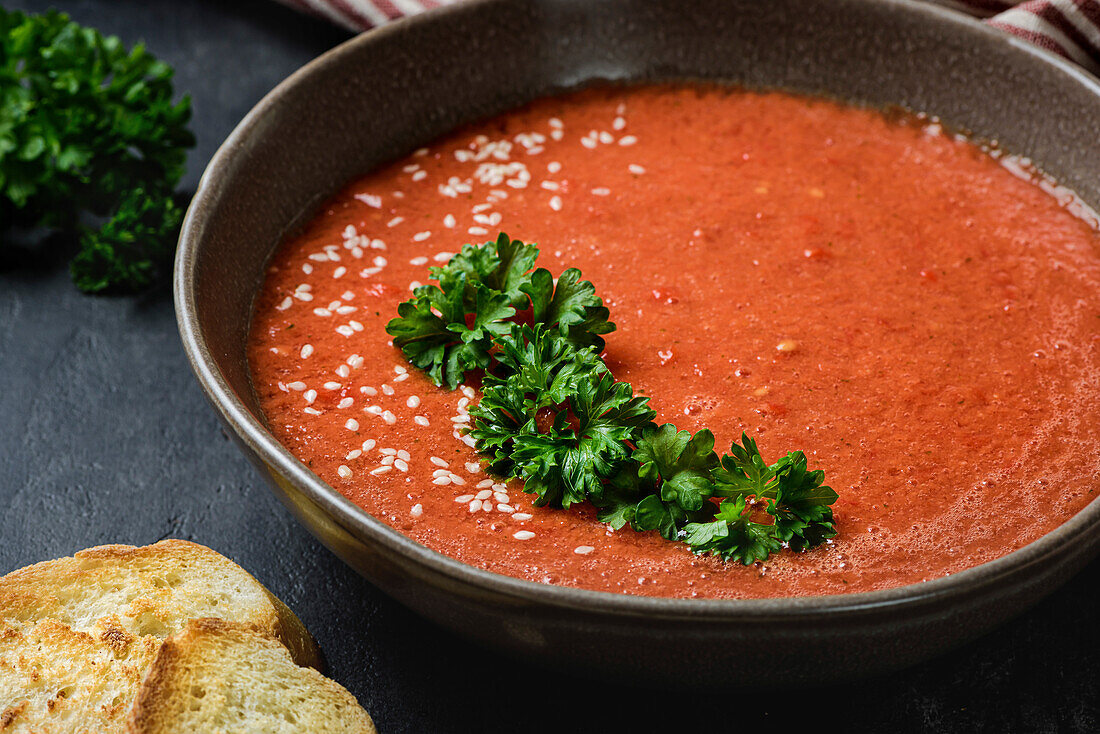 Gazpacho garnished with parsley in a plate with a wavy rim