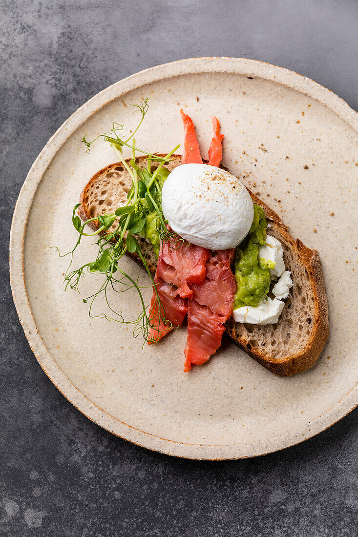 Sandwich with red fish, guacamole and poached egg