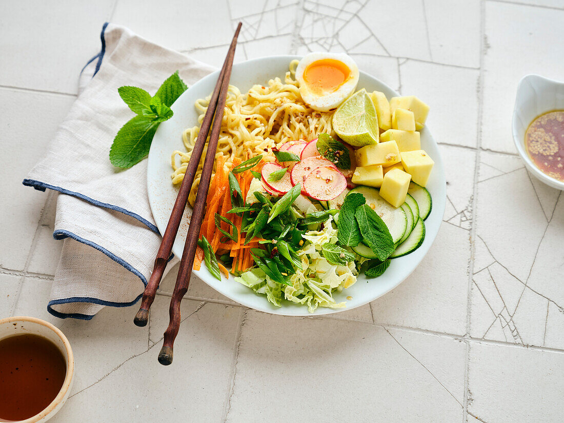 Salat Ramen - vegetarisches Gericht mit Eiernudeln, Mango, Limette und Gemüse. Gesunde panasiatische Küche