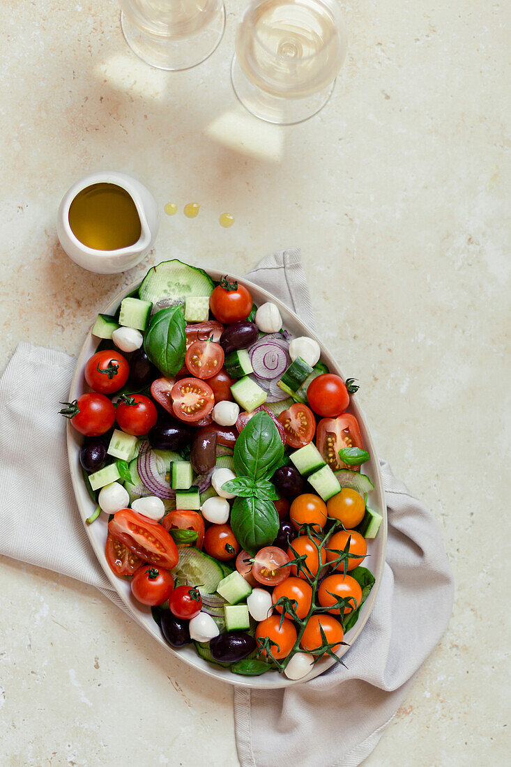 Bowl of Greek salad on a light-coloured background